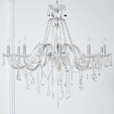 a crystal chandelier hanging from the ceiling in a room with white walls and flooring