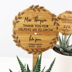 a couple of wooden signs sitting on top of a table next to succulents