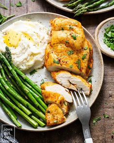 a plate with chicken, mashed potatoes and asparagus