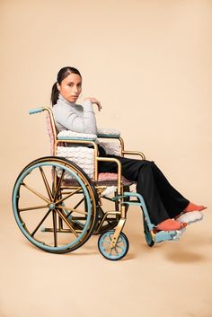 a woman sitting in a wheel chair with one leg on the back of her wheelchair