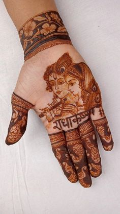 the hand is decorated with henna and an image of lord ganesha on it