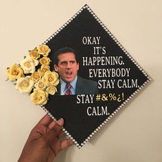 a hand holding up a graduation cap with the words okay it's happening everybody stay calm