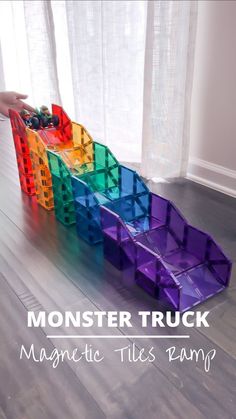 a plastic truck made out of legos on the floor with text overlay reading monster truck magnetic tiles ramp