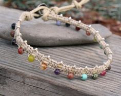 a close up of a bracelet on top of a wooden table next to a rock