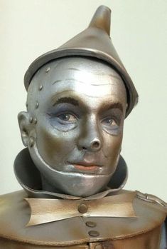 a close up of a statue of a man wearing a hat and armor with his eyes closed