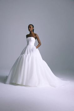 a woman in a white wedding dress posing for a photo with her hands on her hips