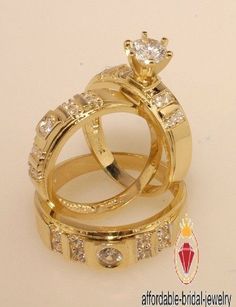 two gold wedding rings with diamonds on each one and an engagement ring in the middle