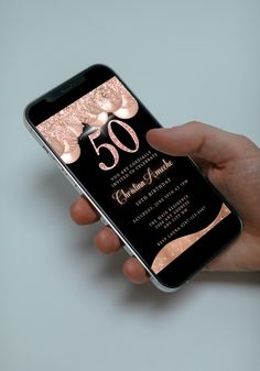 a person holding an iphone with the 50th anniversary card on it