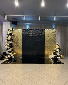 a large black and gold display in the middle of a room with white tile flooring