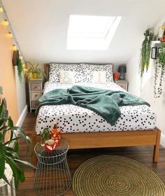 a bedroom with a bed, rugs and potted plants on the side table