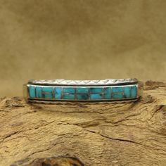 This vintage cuff bracelet is a beautiful piece of Southwestern-inspired jewelry. The sterling silver metal and turquoise stones make for a striking combination. The bracelet has an inside measurement of 5 1/8" with an additional 3/4" gap. The face of the bracelet measures 7/16" tall by 2" wide. There is no artist's hallmark or stamp on the cuff. The bracelet is handmade and inlaid with turquoise, giving it a unique and authentic feel. With a style that is both classic and timeless, this bracele Southwestern Turquoise Bangle, Southwestern Turquoise Cuff Bracelet With Inlay, Southwestern Style Turquoise Cuff Bracelet With Inlay, Vintage Cuff Bracelet, Turquoise Stones, Inspired Jewelry, Silver Turquoise, Turquoise Sterling Silver, Turquoise Stone