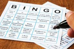 a person is holding a pen and writing the word bingo on two sheets of paper