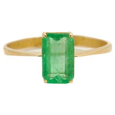 A gorgeous yellow gold vintage emerald cut emerald ring. The natural emerald gemstone has a rich vibrant color and is set in a classic gold band rendered in 18 karat yellow gold. The step cut faceted rectangle green emerald sits along with four soft rounded prongs. Behind the emerald stone the gold frame has an openwork design which ensures optimal light transmission through the stone. Emeralds always gives a mysterious allure. Emerald is a life-affirming stone. It opens the heart chakra and cal Gold Solitaire Emerald Cut Emerald Ring, Classic Rectangular Emerald Gemstone Ring, Fine Jewelry Gold Emerald Cut Emerald Ring, Gold Emerald Cut Emerald Ring Fine Jewelry, Gold Emerald Cut Ring In Fine Jewelry Style, Gold Octagon Solitaire Emerald Ring, Classic Gold Octagon Emerald Ring, Fine Jewelry Emerald Cut Yellow Gold Emerald Ring, Gold Solitaire Emerald Ring In Octagon Shape