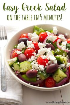 a salad with cucumbers, tomatoes, olives and feta cheese in it