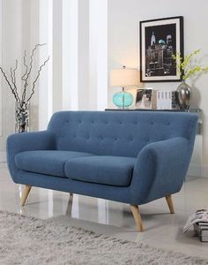 a blue couch sitting on top of a white rug