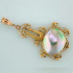 This 10k Yellow Gold Fillagree Pendant Holds A Lusterous Mother-Of-Pearl. Elegant Engraved Mother Of Pearl Jewelry, Elegant Iridescent Mother Of Pearl Jewelry, Elegant Iridescent Jewelry With Pearl Charm, Elegant Iridescent Jewelry For Anniversary, Iridescent Elegant Jewelry For Anniversary, Ornate Oval Pearl Pendant Jewelry, Elegant Iridescent Jewelry With High Luster, Elegant Iridescent High Luster Jewelry, Elegant Iridescent High-luster Jewelry