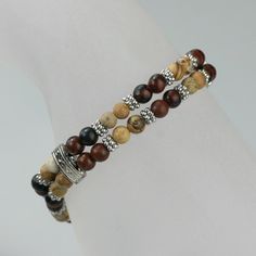 This double strand bracelet is handmade using the semi precious stone Picture Jasper. Picture Jasper is a grounding and harmonizing stone with a strong connection to the earth. It promotes feelings of responsibility towards the planet, encouraging a need to care for and protect it. The length of the necklace is 7-8 1/4 inches, 18-21cm. Brown is a color of physical comfort, simplicity and quality. It gives reassurance. It is quietly confident but never the life of the party! Brown does not seek a Elegant Adjustable Wrap Bracelet With Natural Stones, Brown Stackable Beaded Bracelets Gift, Gift Stackable Brown Beaded Bracelets, Gift Brown Stackable Beaded Bracelets, Adjustable Double Strand Bracelet As Gift, Adjustable Double Strand Bracelet For Gift, Brown Gemstone Beads Wrap Bracelet Gift, Brown Natural Stone Wrap Bracelet Gift, Earthy Hand Wrapped Wrap Bracelet As Gift