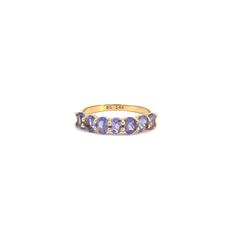 a yellow gold ring with five tan and purple stones on the band, set in 18k yellow gold