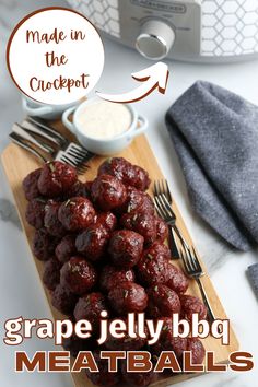 grape jelly bbq meatballs on a cutting board with fork, knife and napkin