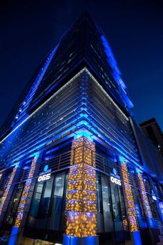 a tall building with blue lights on it's side and the words ocb in front of it