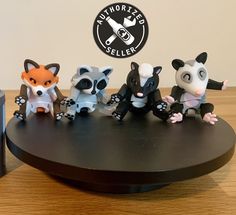 a group of small figurines sitting on top of a wooden table next to a camera