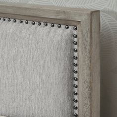 an upholstered headboard with metal studs on it