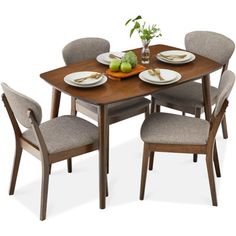 a dining table with four chairs and plates on it, set against a white background