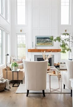 a living room filled with white furniture and lots of windows on top of the walls