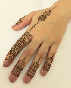 a woman's hand with henna tattoos on it