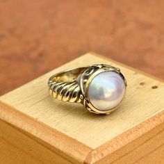 New, but old pieces, never worn, recently acquired from a premier jeweler located in Minneapolis, MN for many years- A rare opportunity! 14KT yellow gold genuine, bezel-set, Mabe pearl ring with Etruscan/ filigree design. Size 6.25 Sizable by us for a fee or your local jeweler Weight: 7.90 grams Band width: 4mm 11mm pearl Stamped 14k Luxury Domed Collectible Jewelry, Luxury Collectible Domed Jewelry, Elegant Domed Moonstone Gemstone Ring, Elegant White Domed Rings, Elegant White Domed Jewelry, Classic Formal Cabochon Moonstone Ring, Classic White Gold Cabochon Jewelry, Classic Oval Cabochon Collectible Jewelry, Heirloom Jewelry With Oval Cabochon And Polished Finish