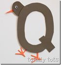 the letter q is made out of paper and has an orange bird on it's tail