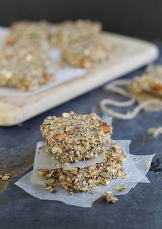 three granola bars stacked on top of each other next to a wooden cutting board