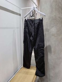 Relaxed fit cargo pants with a diagonal zipper along the front and drawstring ankles.    vendor colour: black    vendor style: ys20fwpt004    fabrication: 100% nylon    made in korea. Fit Cargo Pants, Easy Tiger, Caged Sandals, Black Tank Dress, Black Aviators, Neon Purple, Boyfriend Tee, Ruched Dress, Tank Dress