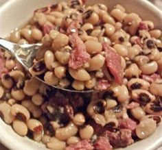 a white bowl filled with beans and meat