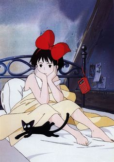 a woman laying in bed with a black cat next to her and a red phone