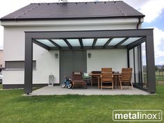 a patio covered with chairs and tables next to a garage door on the side of a house