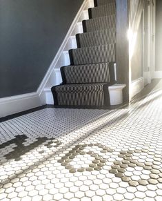 a stair case next to a set of stairs in a room with tiled flooring