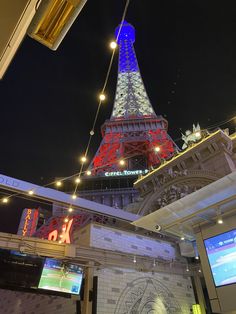 the eiffel tower is lit up in red, white and blue at night