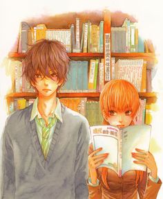 two people standing next to each other in front of a book shelf with books on it