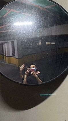 the reflection of two people taking pictures in a mirror