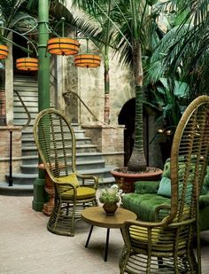 two wicker chairs sitting next to each other on top of a brick floor covered patio