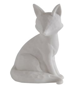 a white cat statue sitting on top of a table