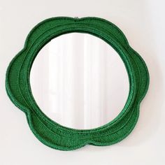 a green circular mirror hanging on the wall