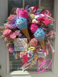 an ice cream cone wreath is decorated with pink, blue, and yellow ribbons for the front door