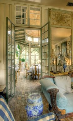 a living room filled with furniture next to a doorway leading into a dining room area