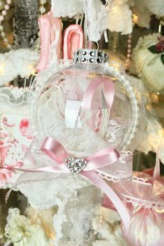 an ornament hanging from a christmas tree decorated with pink ribbons and bows,