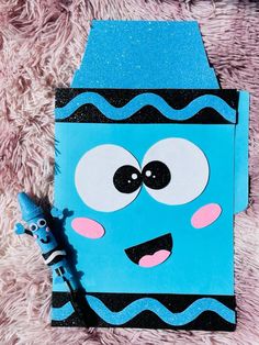 a blue paper bag with an image of a cartoon character on it and a marker next to it