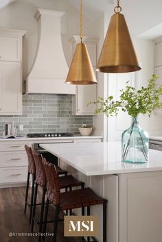 a kitchen with three pendant lights hanging from the ceiling