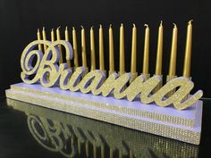 a birthday cake with candles and the word obama spelled out in gold on it's stand