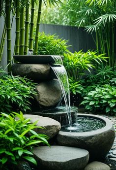 a water fountain surrounded by rocks and plants